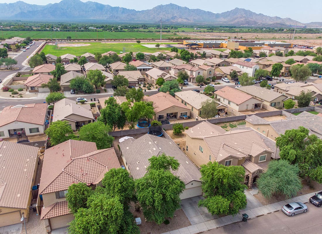 Gilbert, ZA - Aerial view of residential homes in Gilbert, ZA with mountains in the background